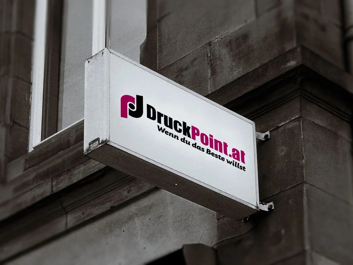 Beleuchteter Firmenausleger von DruckPoint an der Fassade in Wien
